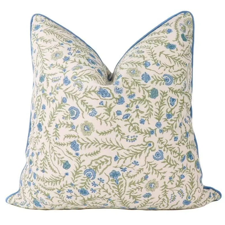 Decorative pillow with blue and green floral pattern on a cream background