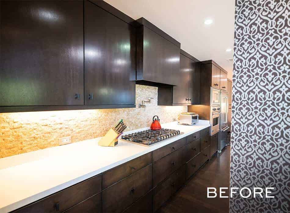 Dark wood kitchen with white countertops and backsplash lighting