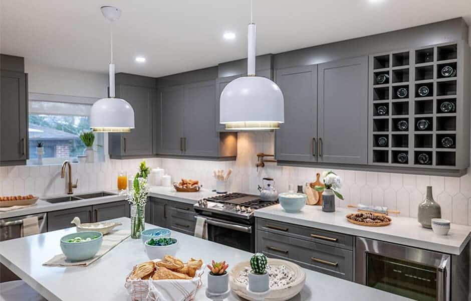 Modern kitchen with gray cabinets, white countertops, and pendant lighting over an island