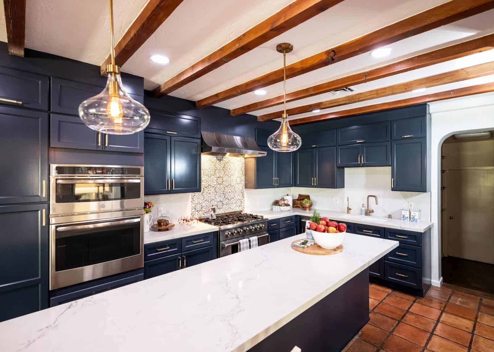 Luxurious kitchen with wood beam ceilings, navy cabinets, and stainless steel appliances