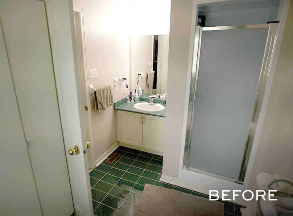 A before image of an outdated bathroom with green tile flooring, a small vanity, and a frosted glass shower door