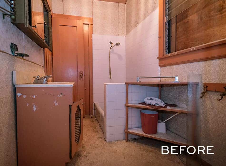 Run-down bathroom with old fixtures, peeling cabinets, and a tiled shower