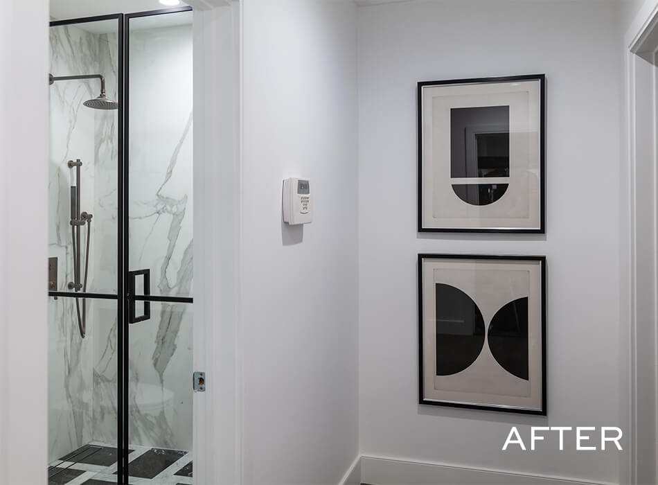 Modern hallway with minimalist artwork and a glass-enclosed marble shower