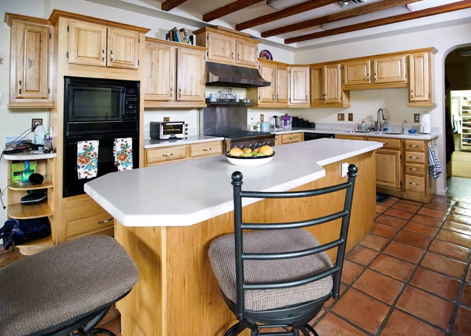 A spacious kitchen with warm-toned wood cabinets and a white countertop island